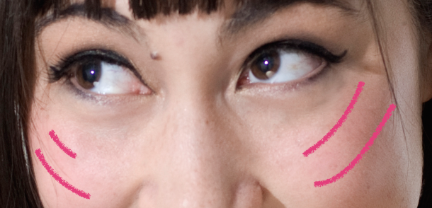 Image shows example of where to place blush - two downward curving lines on the upper part of the cheeks.