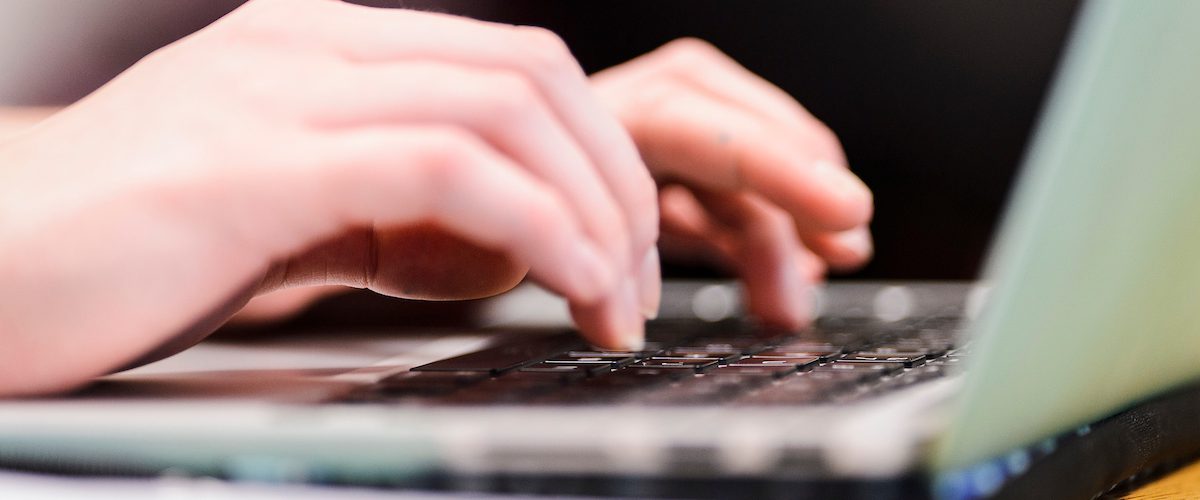 A close-up shot of hands typing at a laptop, suggesting a training session